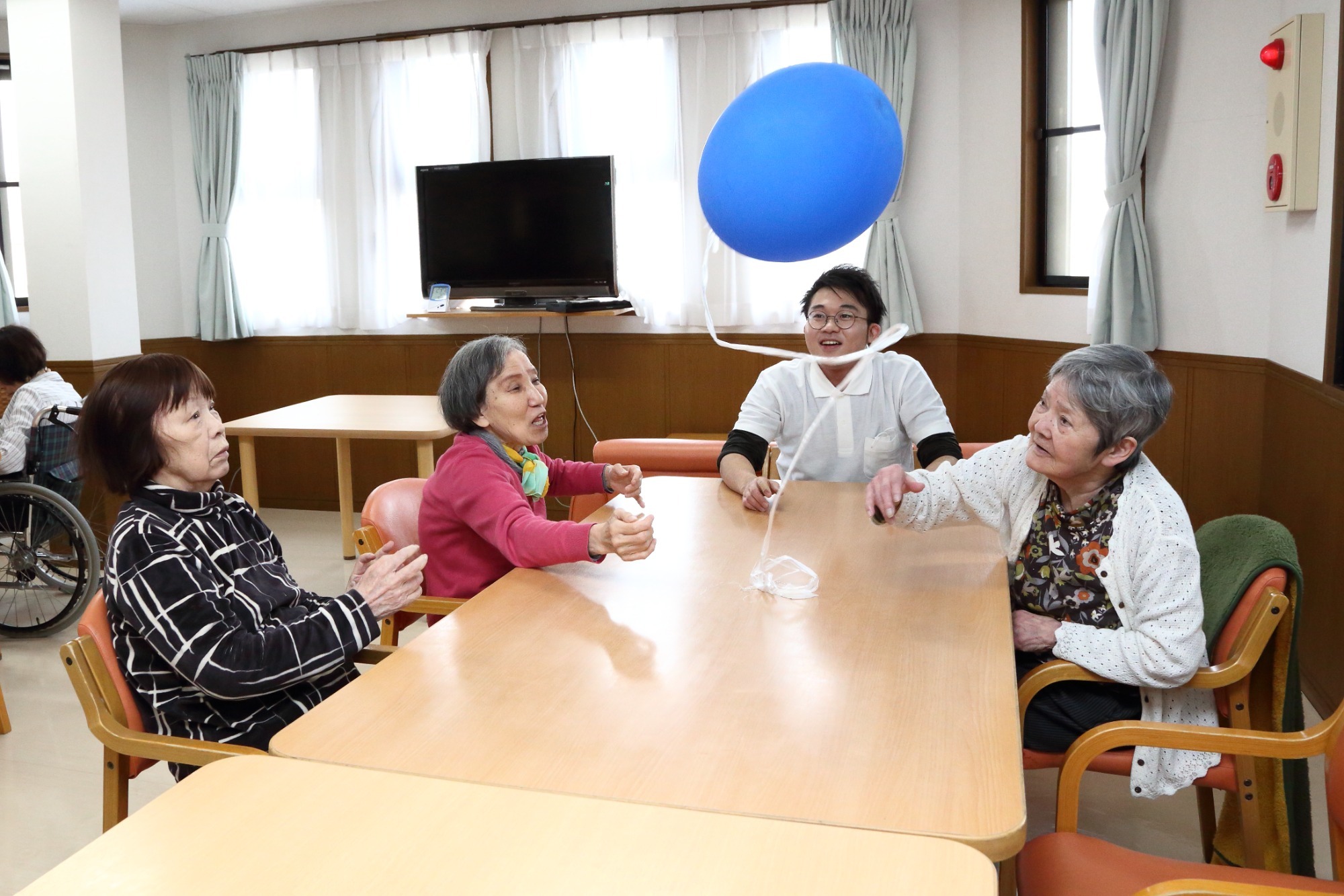 介護施設でのレクリエーション。入居者がボール遊びを楽しむ様子。